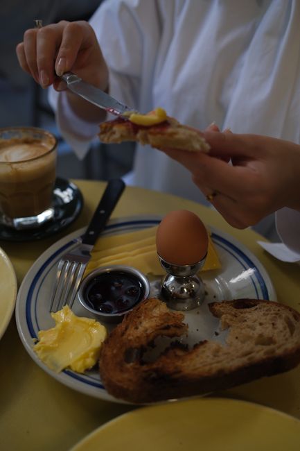 A delicious breakfast setup with bread, coffee, and boiled egg.