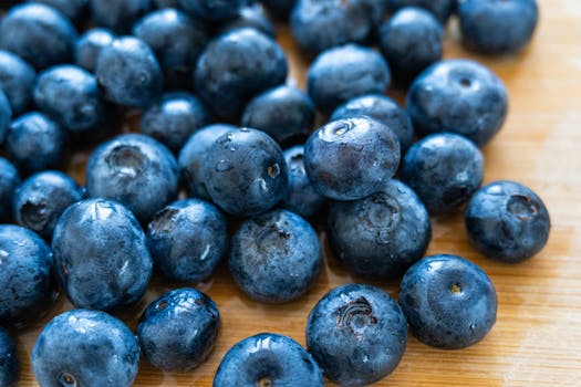 Close-up of fresh blueberries on a wooden surface highlighting natural freshness and texture.