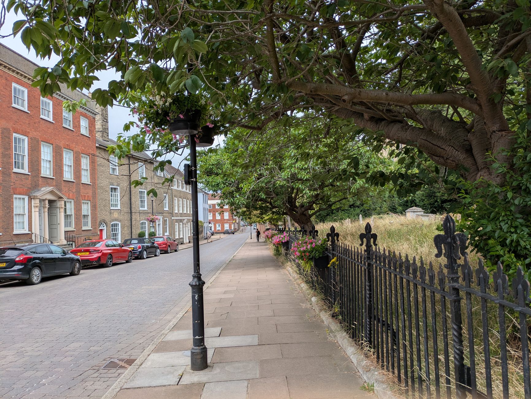 Quaint street in Bury St Edmunds, England, with historic architecture and lush greenery