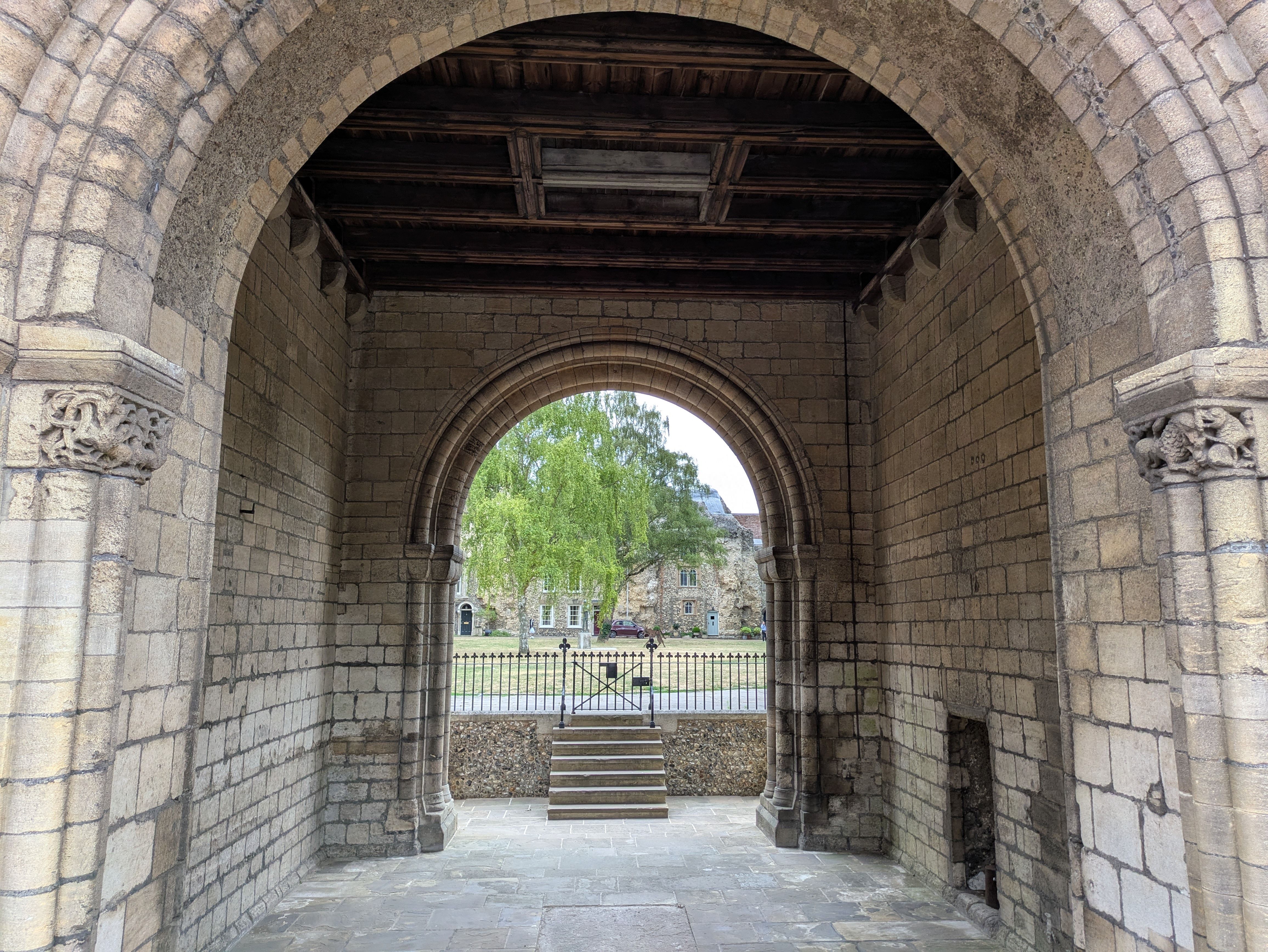 Stone archway view leading to lush courtyard in historic abbey ruins. - Abbey de St. Gall