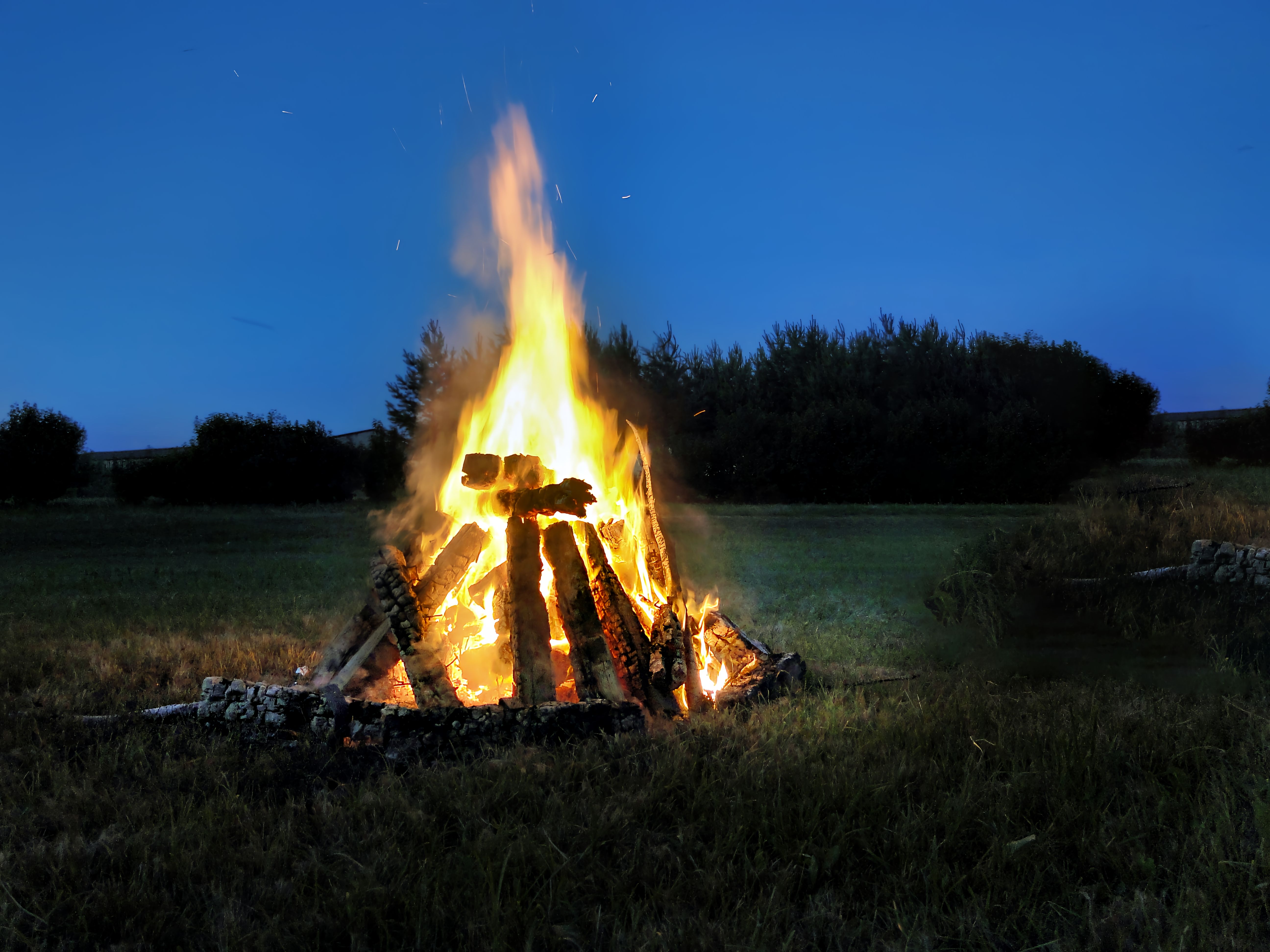 A glowing bonfire burning brightly at night in the Rembate countryside, Latvia.