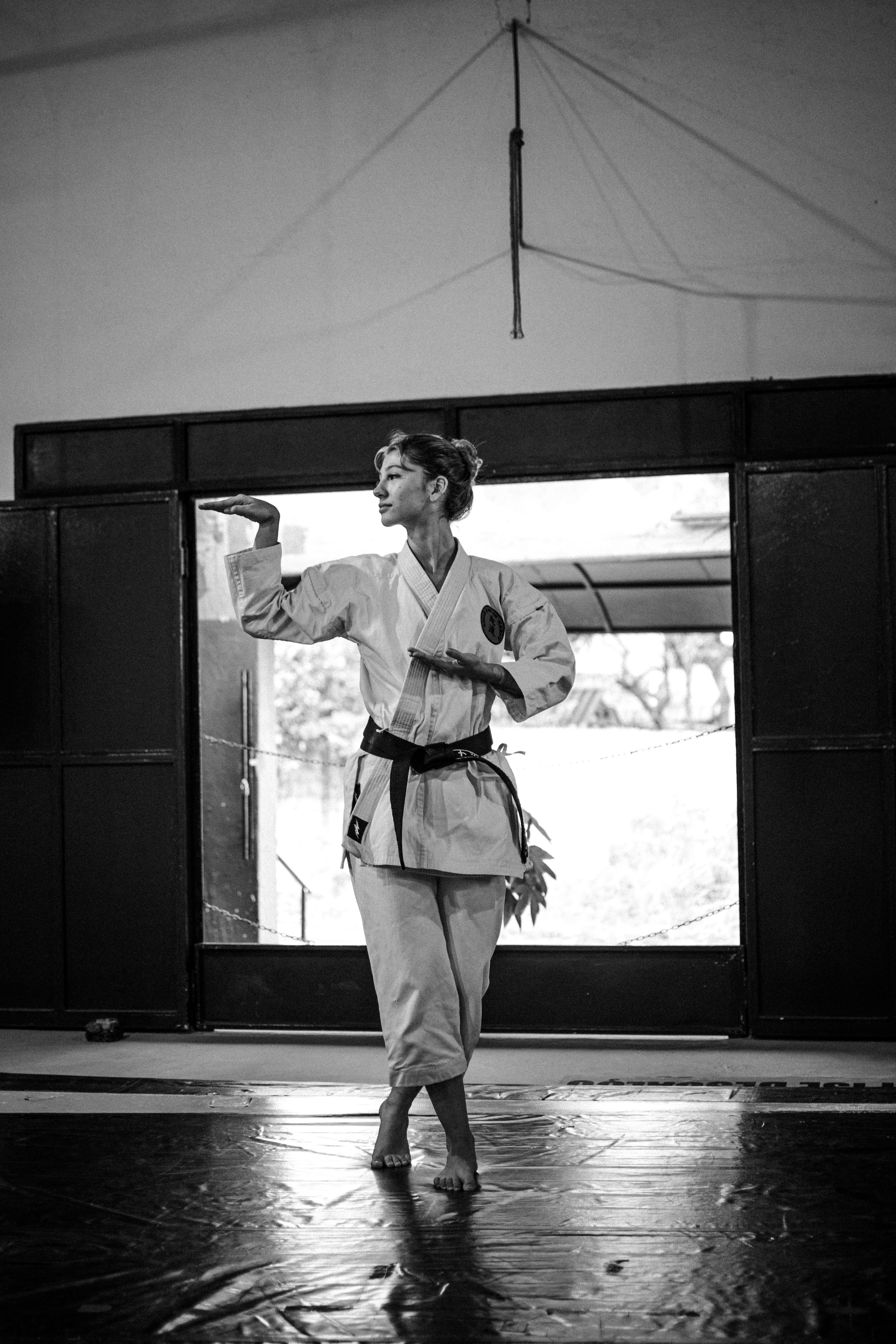 A martial artist performs a kata indoors, showcasing focused discipline and skill.