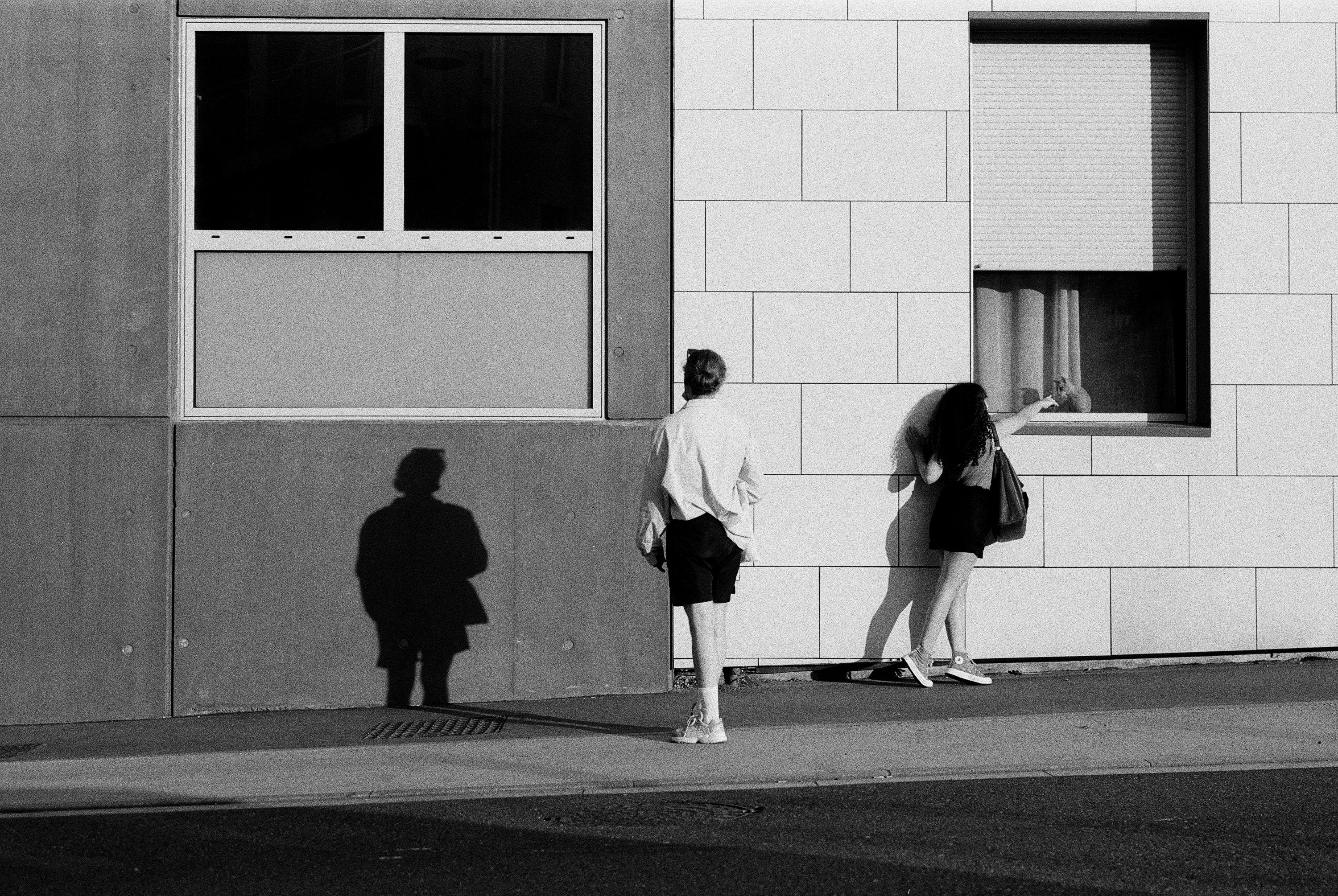 Artistic black and white photo of people interacting in Nancy, France street.