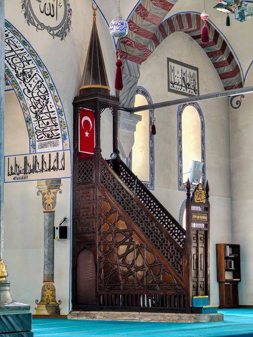 Free Intricate wooden pulpit with Turkish flag in a beautiful mosque interior. Stock Photo