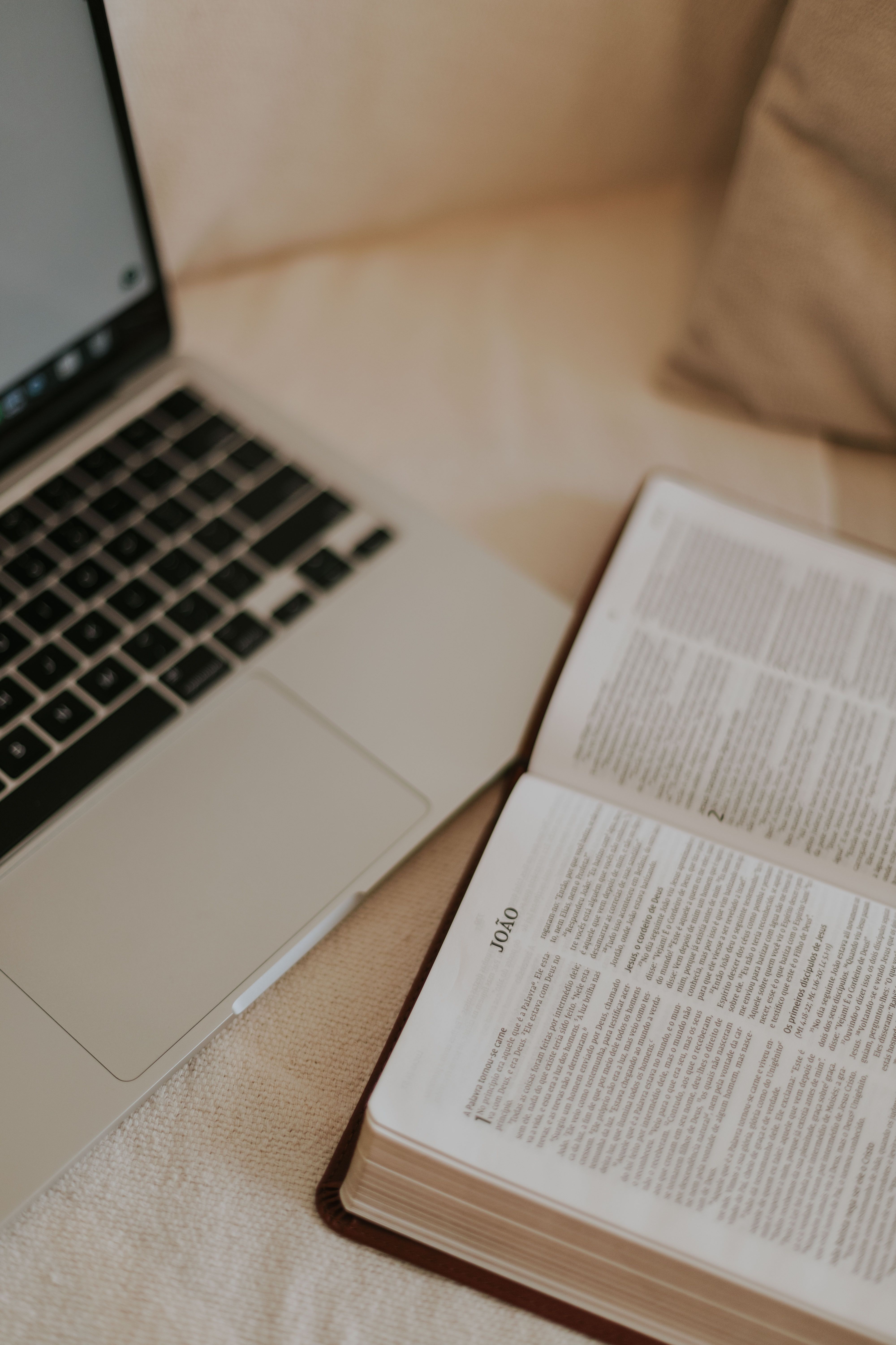 Biblia abierta junto a un portátil, simbolizando la fe cristiana en el trabajo