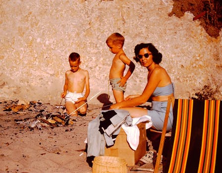 Mother and sons enjoying a beach campfire on a sunny day. Relaxed, vintage vibe.