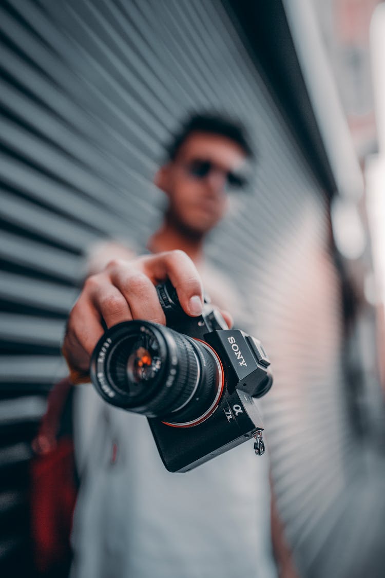 Standing Man Holding Black Sony Dslr Camera