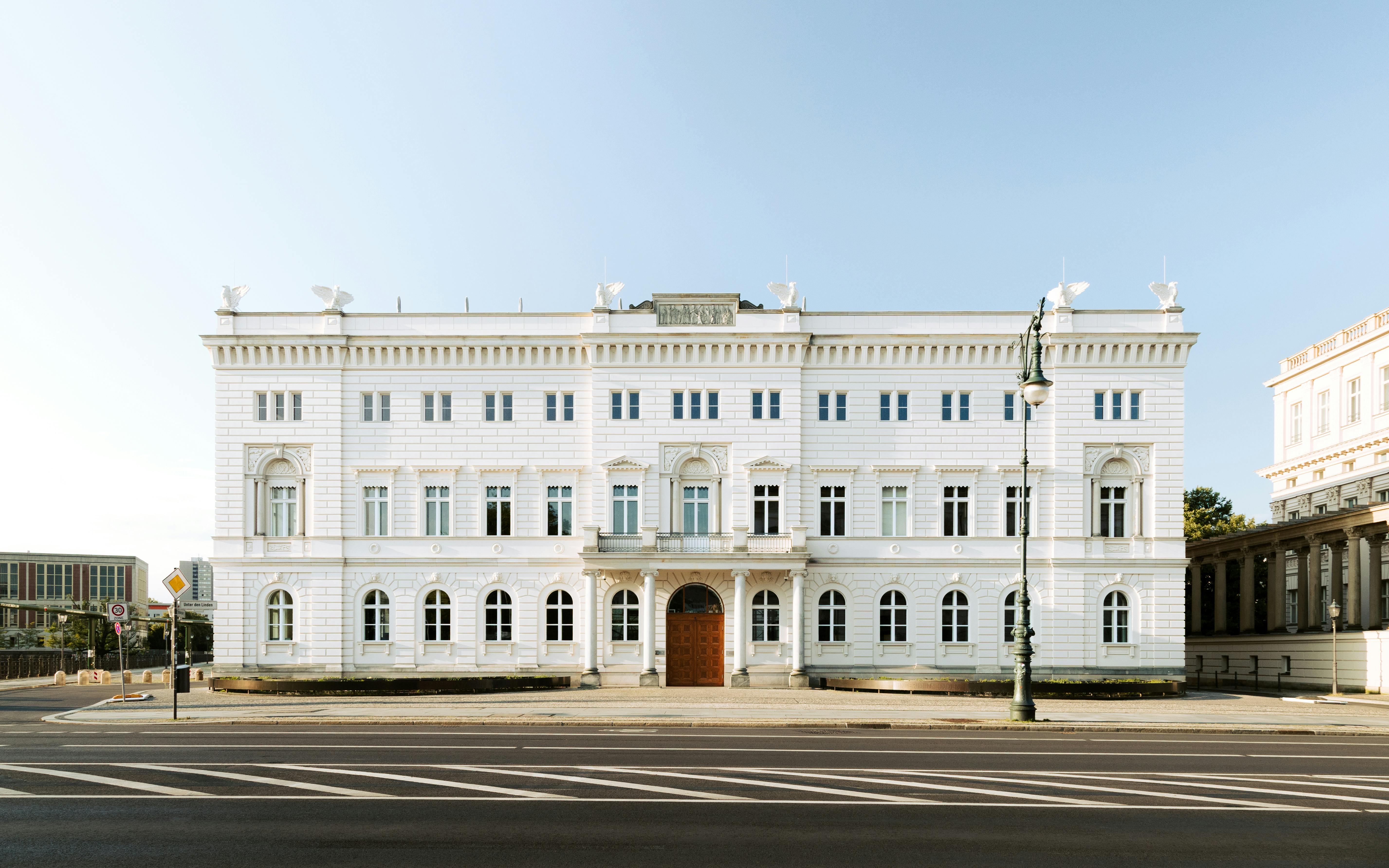 A beautifully symmetrical neoclassical building in Berlin, Germany, captured in soft daylight.