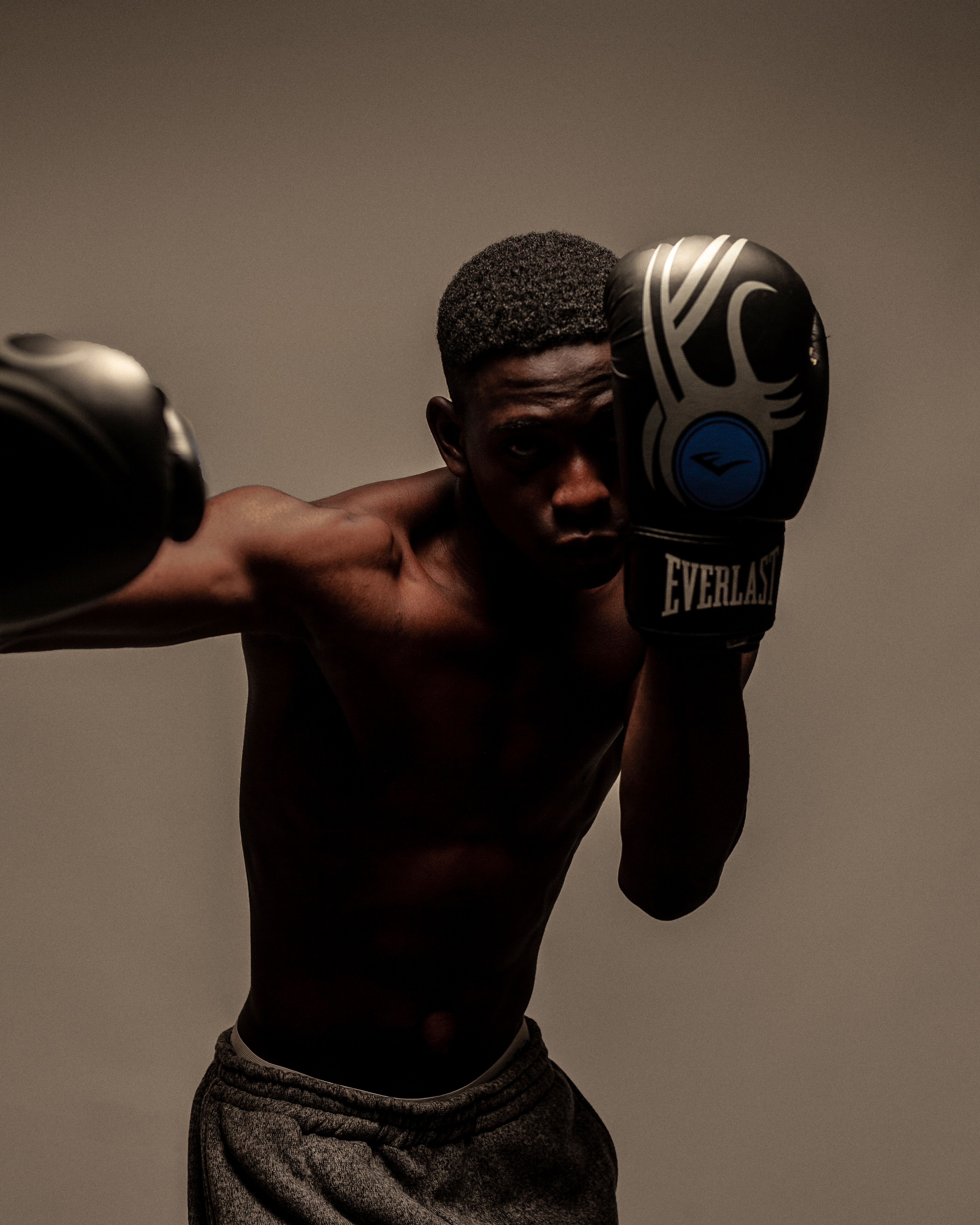 A young male boxer practicing his moves, highlighting skill and determination.