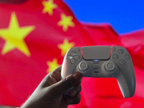 Free Close-up of a hand holding a PlayStation controller in front of a Chinese flag. Captured in London, UK. Stock Photo