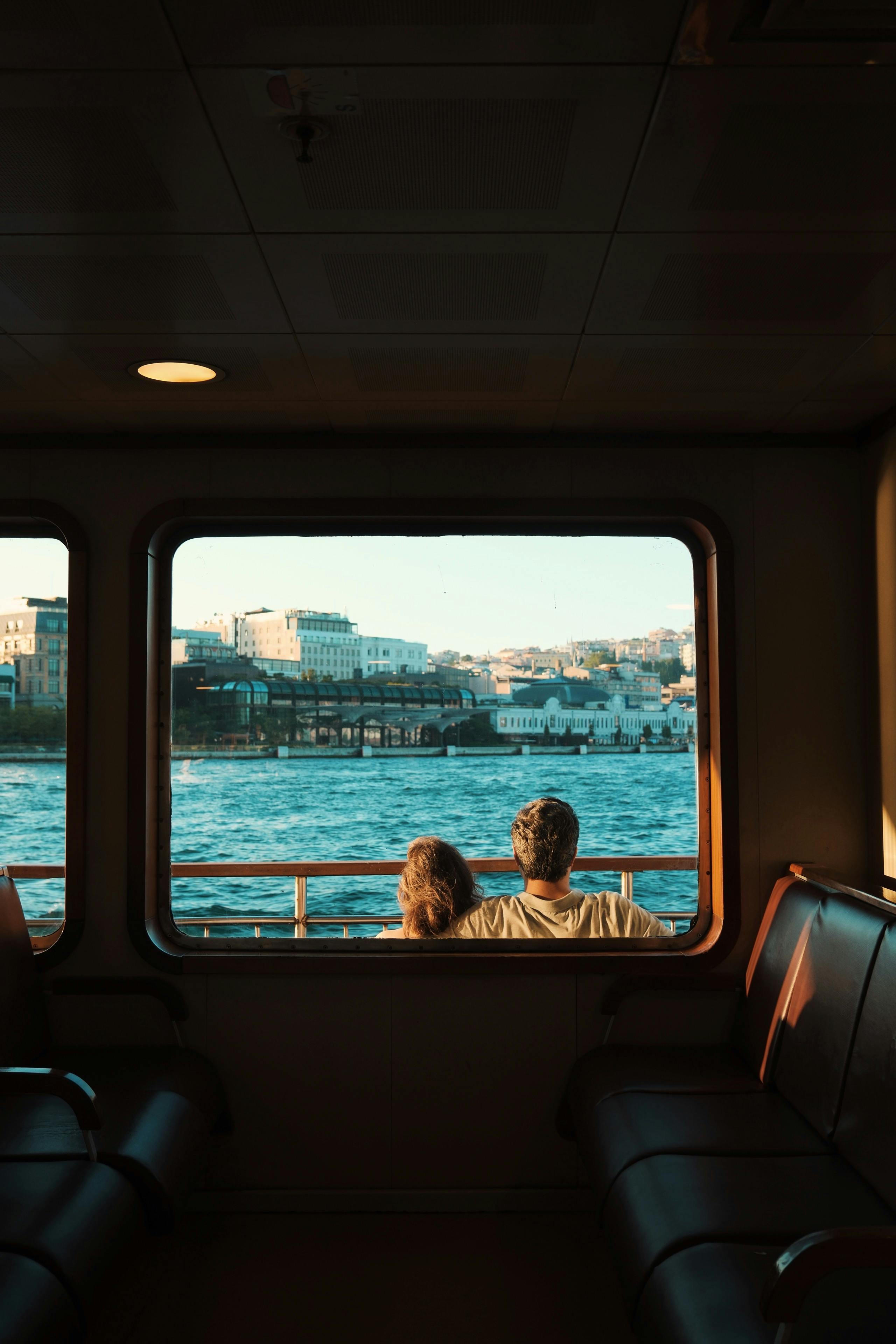 Gratuit Un couple regarde l'horizon d'Istanbul depuis la fenêtre d'un ferry pendant la journée. Photos