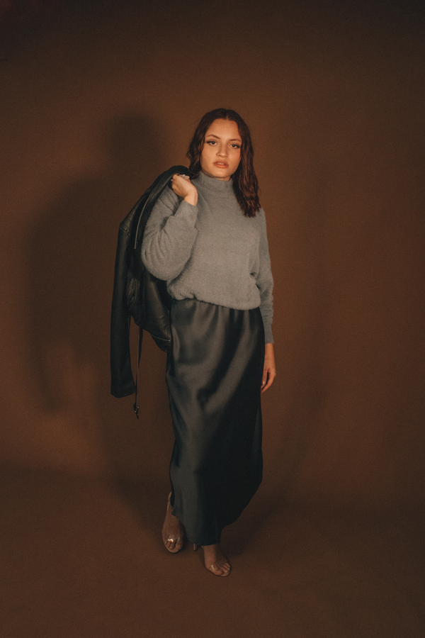Woman in a satin midi skirt with a cashmere turtleneck