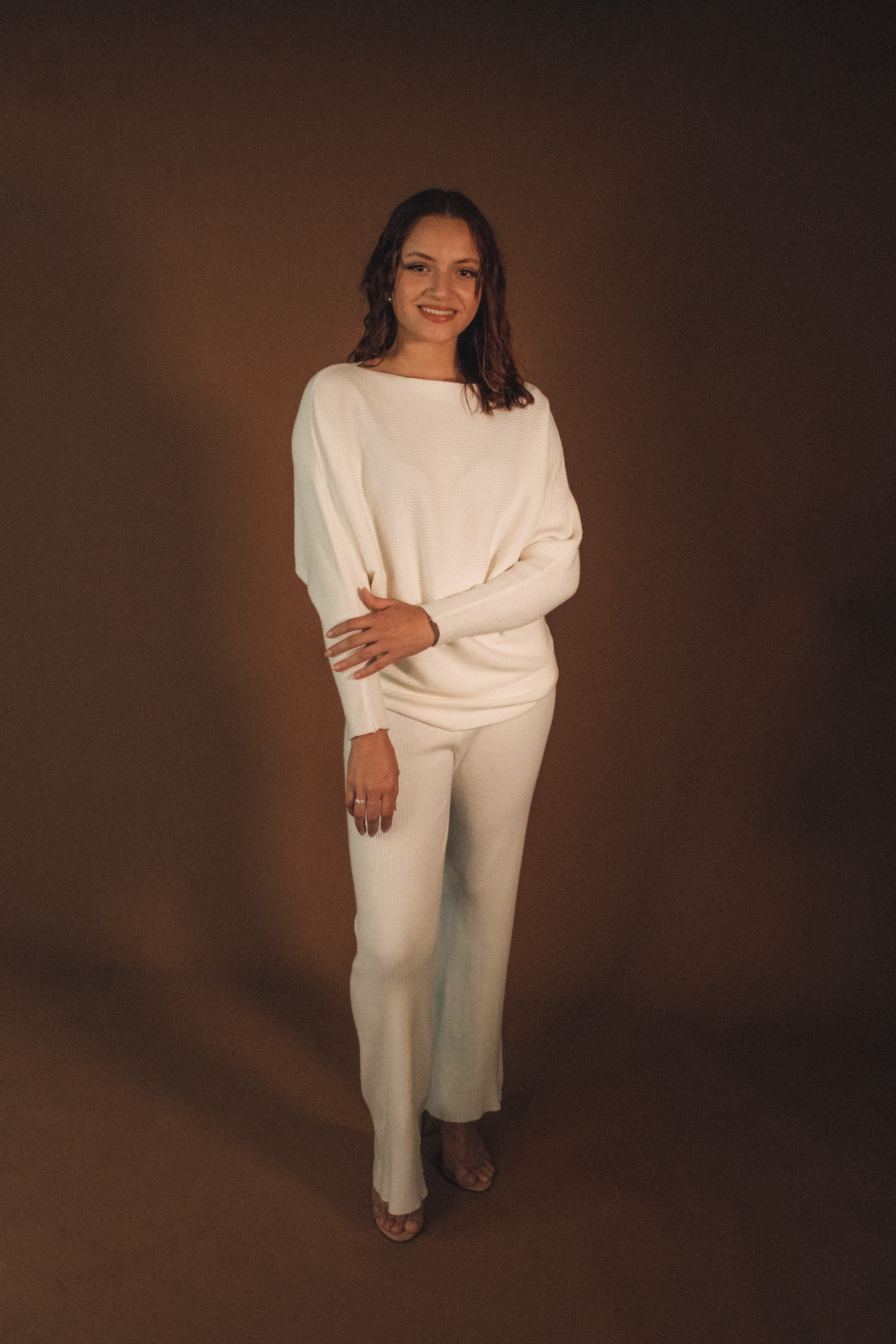 Elegant Woman in White Outfit on Brown Background · Free Stock Photo