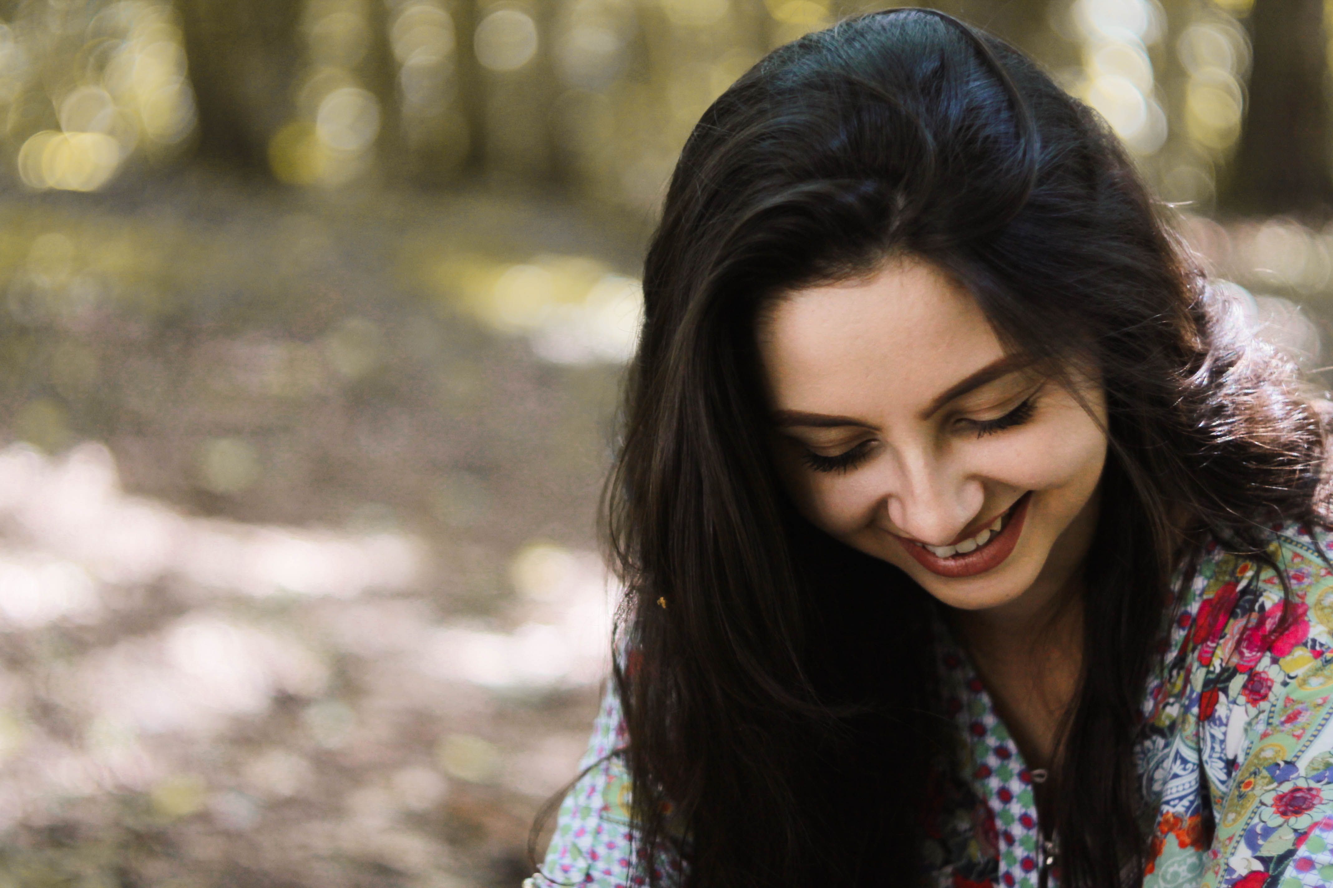 Smiling Woman Outdoors in Floral Shirt · Free Stock Photo