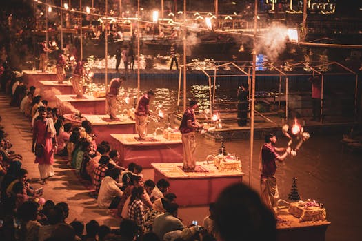 Evening Ganga Aarti ceremony with worshippers on the banks of the Ganges in Varanasi, India.