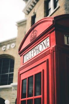 以城市建筑为背景，经典的红色英国电话亭格外醒目