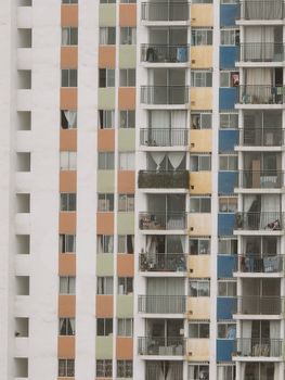 Colorful high-rise building facade with various balconies and windows, showing urban living.