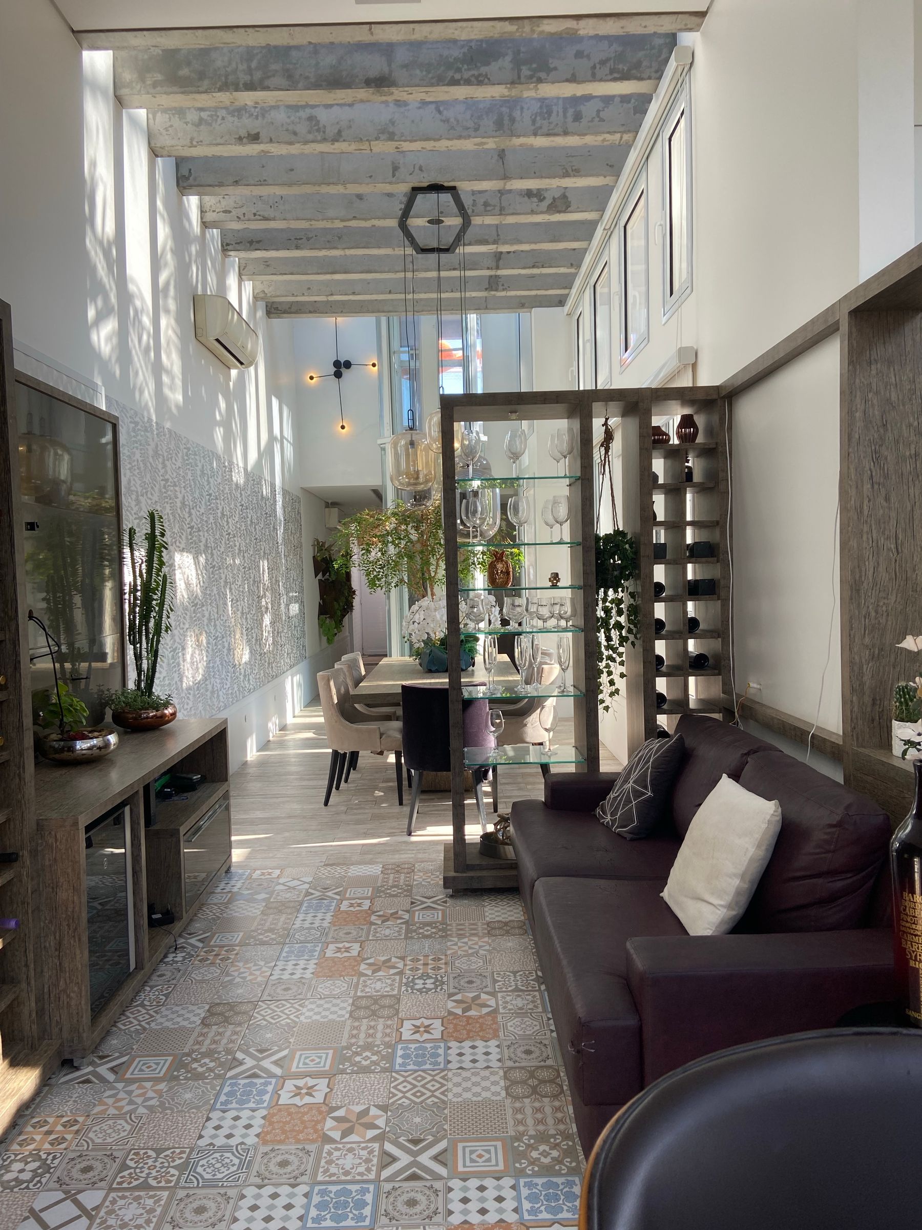 Bright sunlit living room with plants, wood, tile and natural textures