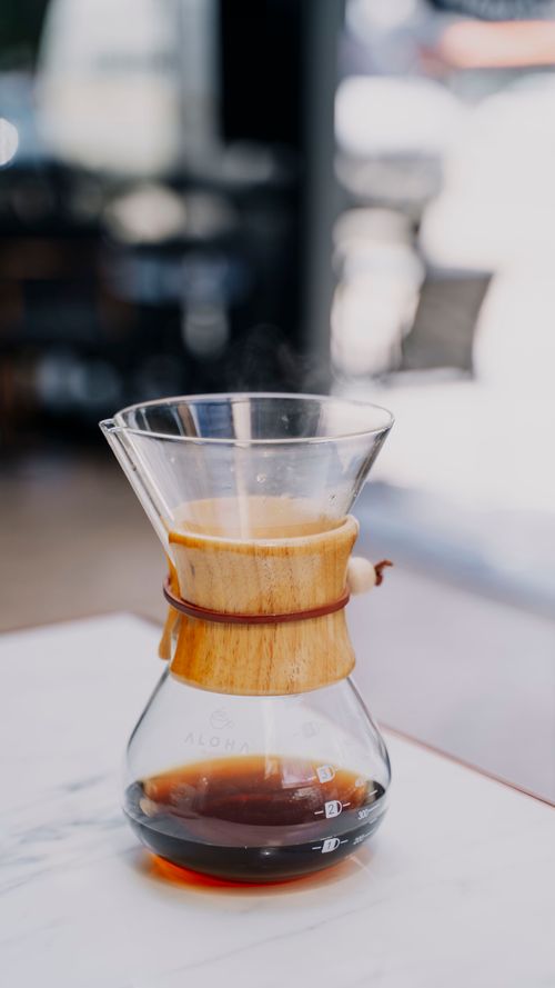 Free Stylish Chemex coffee maker on a modern marble surface, ideal for a cozy cafe setting. Stock Photo