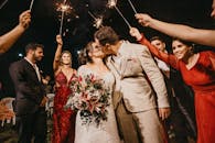 一对快乐的夫妇在婚礼庆祝活动中，于宾客簇拥下接吻