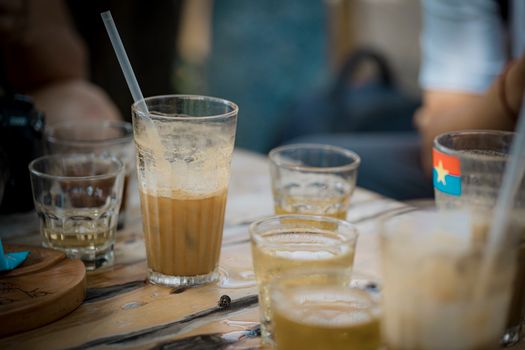 Close-up of iced coffee and drinks in a casual social setting outdoors.