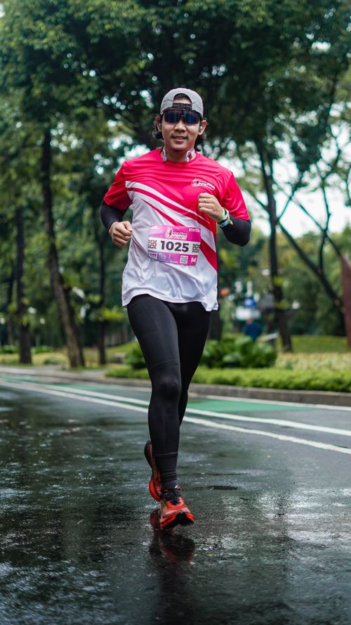 Free Energetic runner in city park during race, mid-action shot. Stock Photo