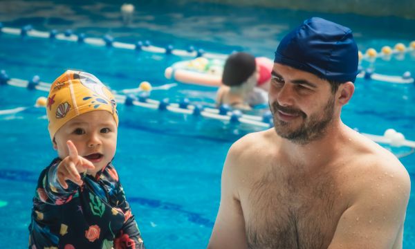 Father and child bonding during a swim lesson at indoor pool