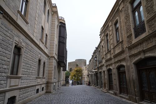 Free Capture of a cobblestone street in Baku's Old City, showcasing traditional stone architecture and the Maiden Tower. Stock Photo