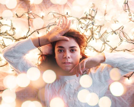 这是一幅温暖舒适的冬日肖像，画中一名女子沐浴在节日的灯光里，营造出浓浓的节日氛围