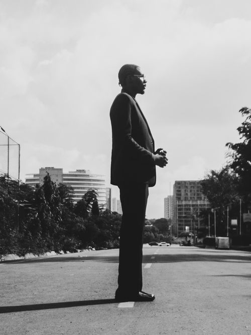 Free Black and white silhouette of a man in a suit standing confidently on a city street. Stock Photo