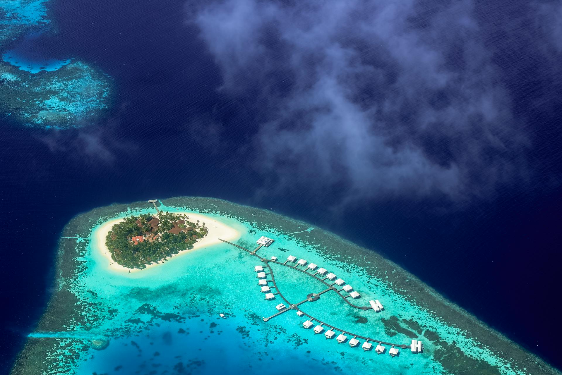 Stunning aerial shot of a tropical island resort surrounded by turquoise waters in the Maldives.