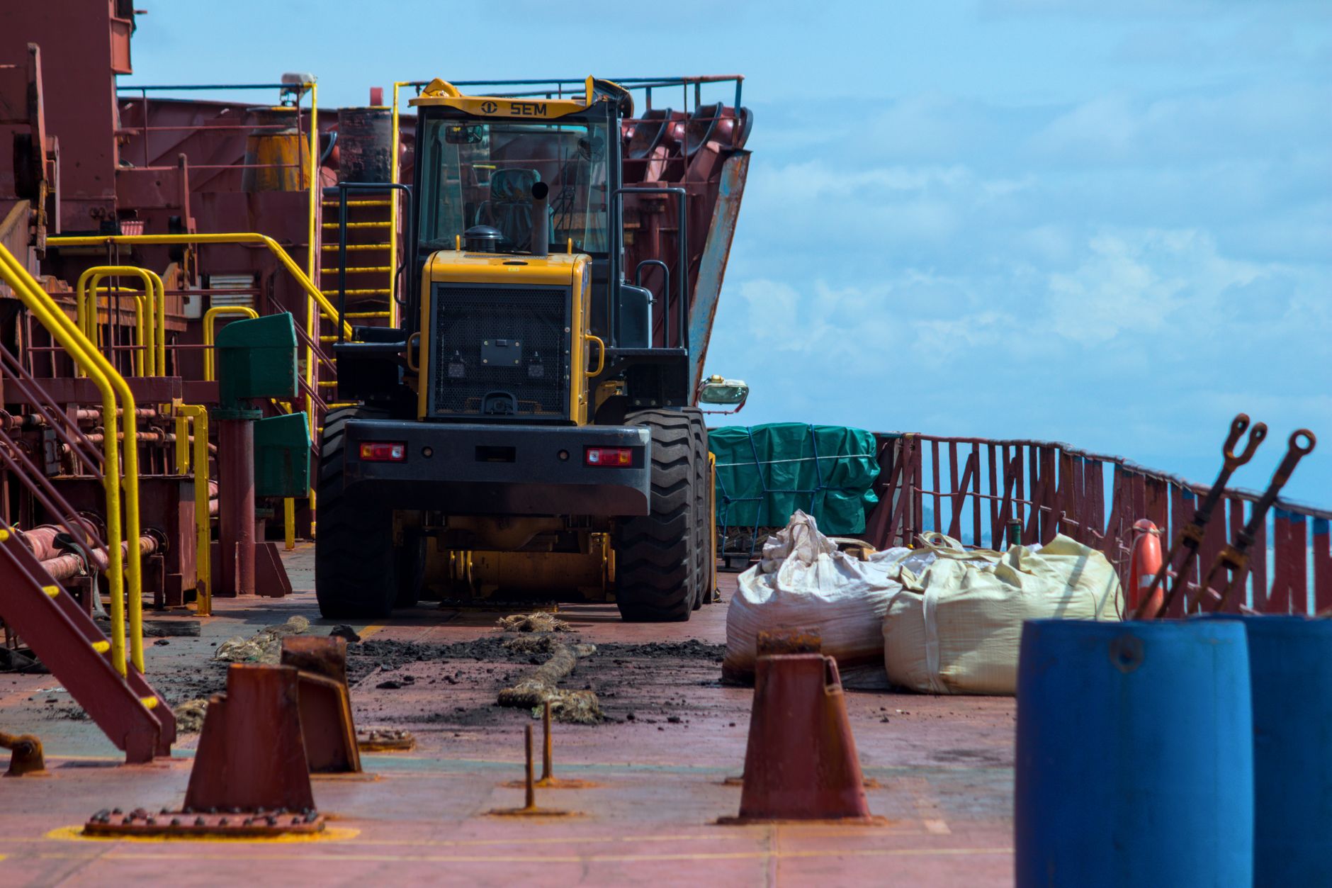 Industrial cargo ship deck with heavy machinery and equipment, showcasing maritime shipping operations.
