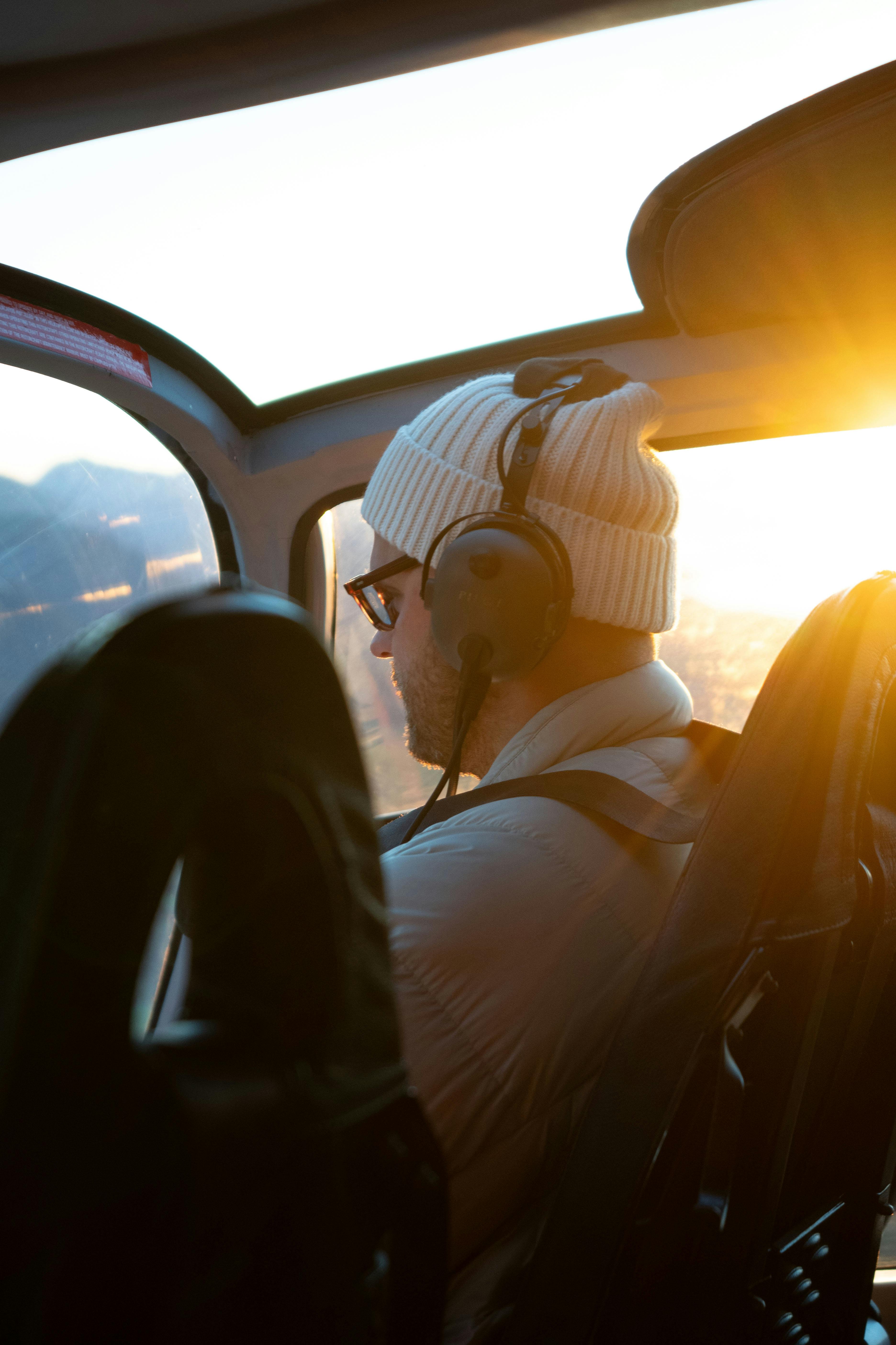 A person enjoying a scenic helicopter ride during sunset over mountains in California.