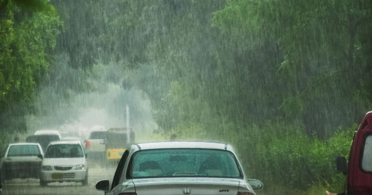 強い雨の中を走る車(イメージ)