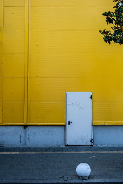 Free A striking yellow wall with a white door in a geometric, minimalist style. Located in İstanbul, Türkiye. Stock Photo