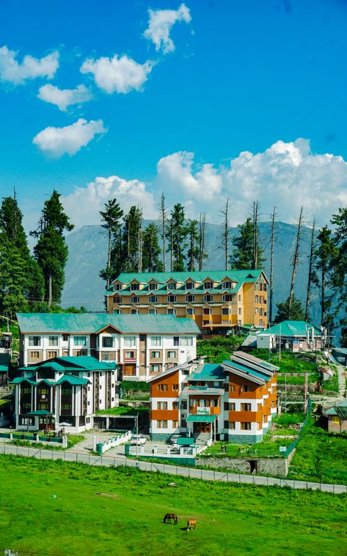 Free Beautiful resort nestled in lush green mountains under a bright blue sky. Stock Photo