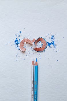 Blue and white pencils with shavings resembling the Argentina flag on textured paper.