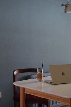 Simple and serene workspace with a laptop and iced coffee, featuring ample copyspace.