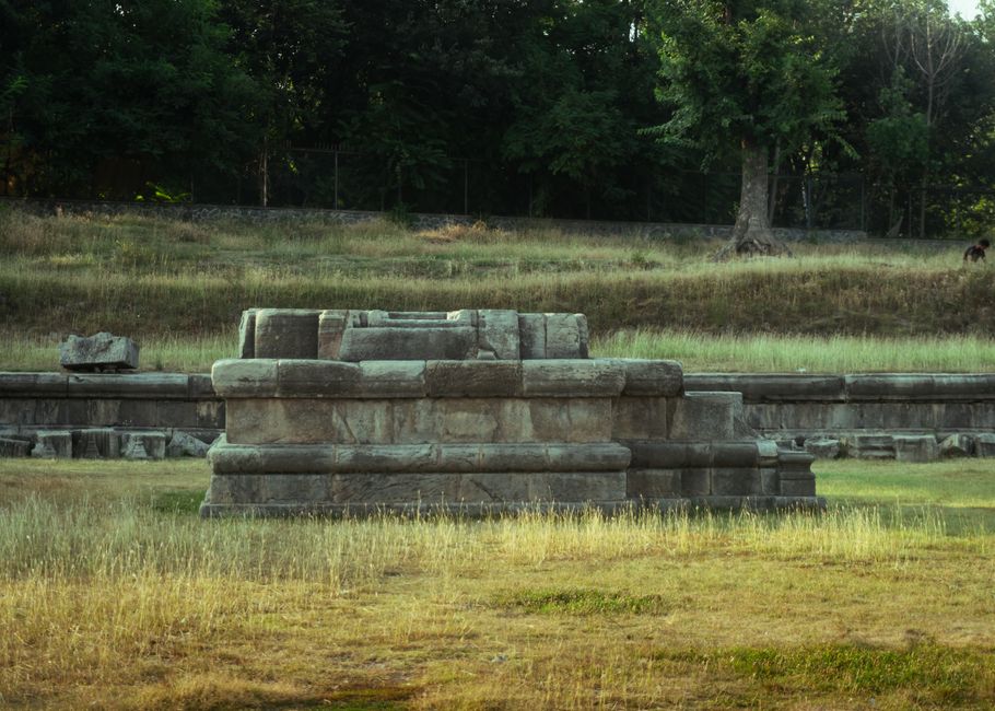 Explore these ancient ruins set in a serene grassy field, perfect for history enthusiasts.