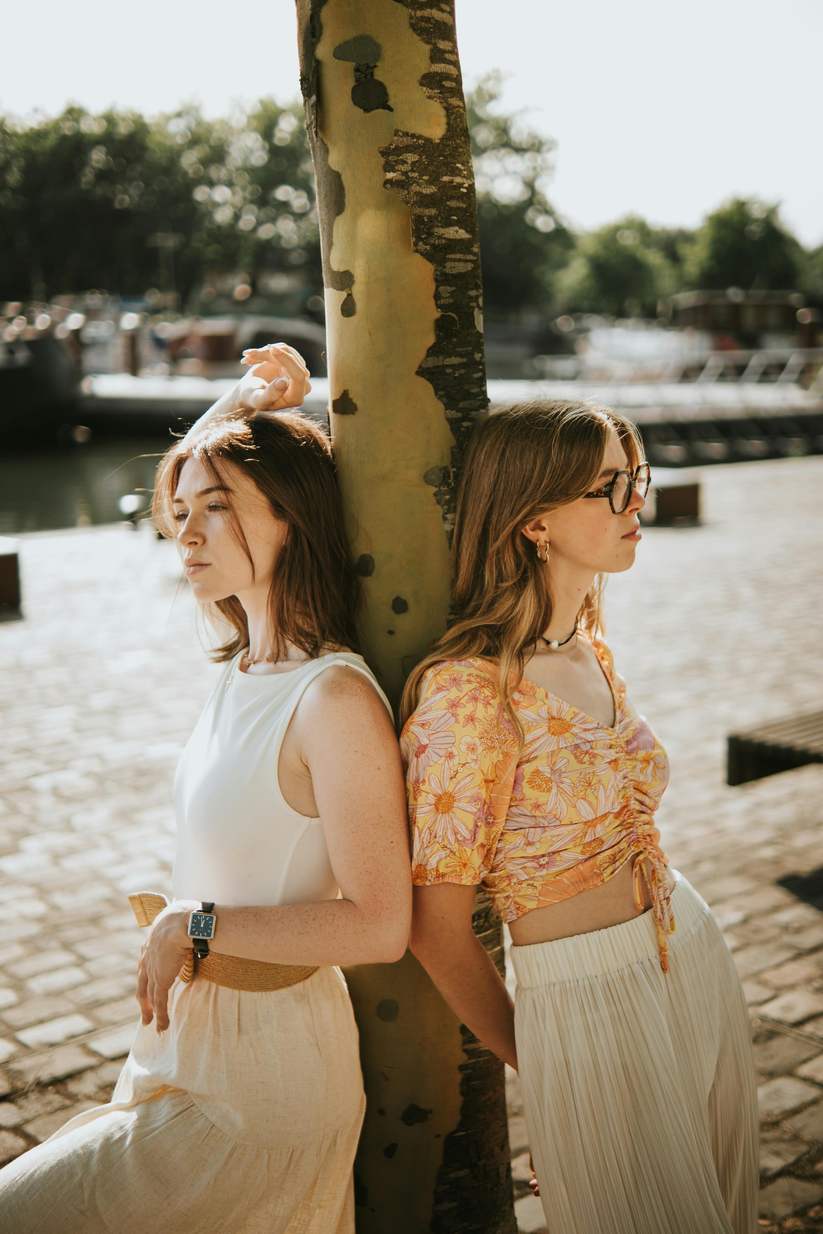 Two young women enjoying a sunny day by the Lille waterfront, showcasing relaxed summer vibes.