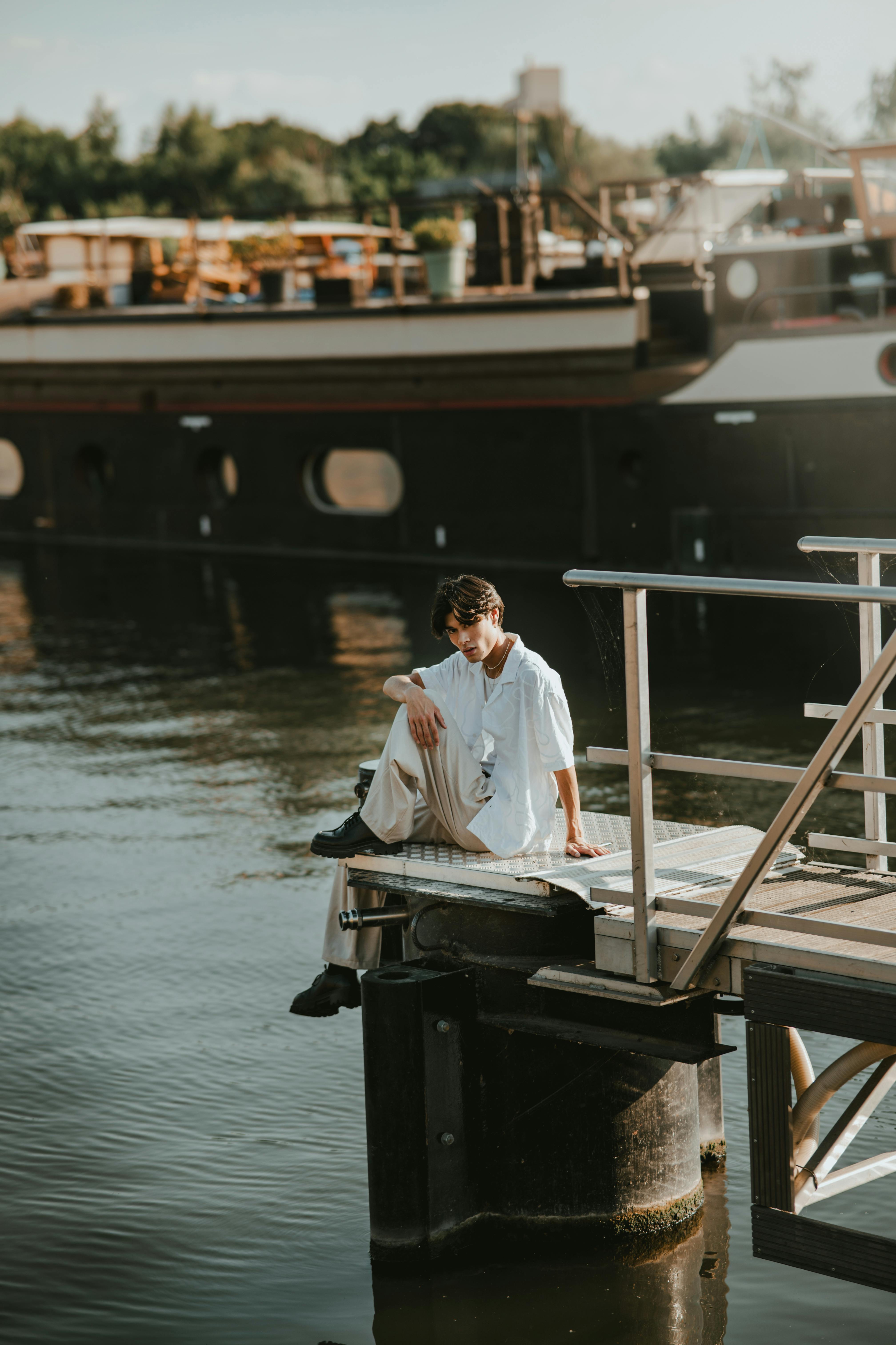 Zadarmo Zamyslený mladý muž sedí sám pri rieke v Lille vo Francúzsku za slnečného dňa. Fotka z fotobanky