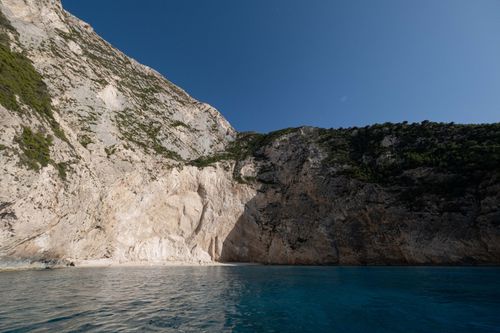 Free Stunning view of a coastal cliff with turquoise waters under a clear blue sky, perfect for nature enthusiasts. Stock Photo