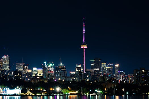 Vibrant Toronto skyline featuring the illuminated CN Tower reflecting over Lake Ontario.