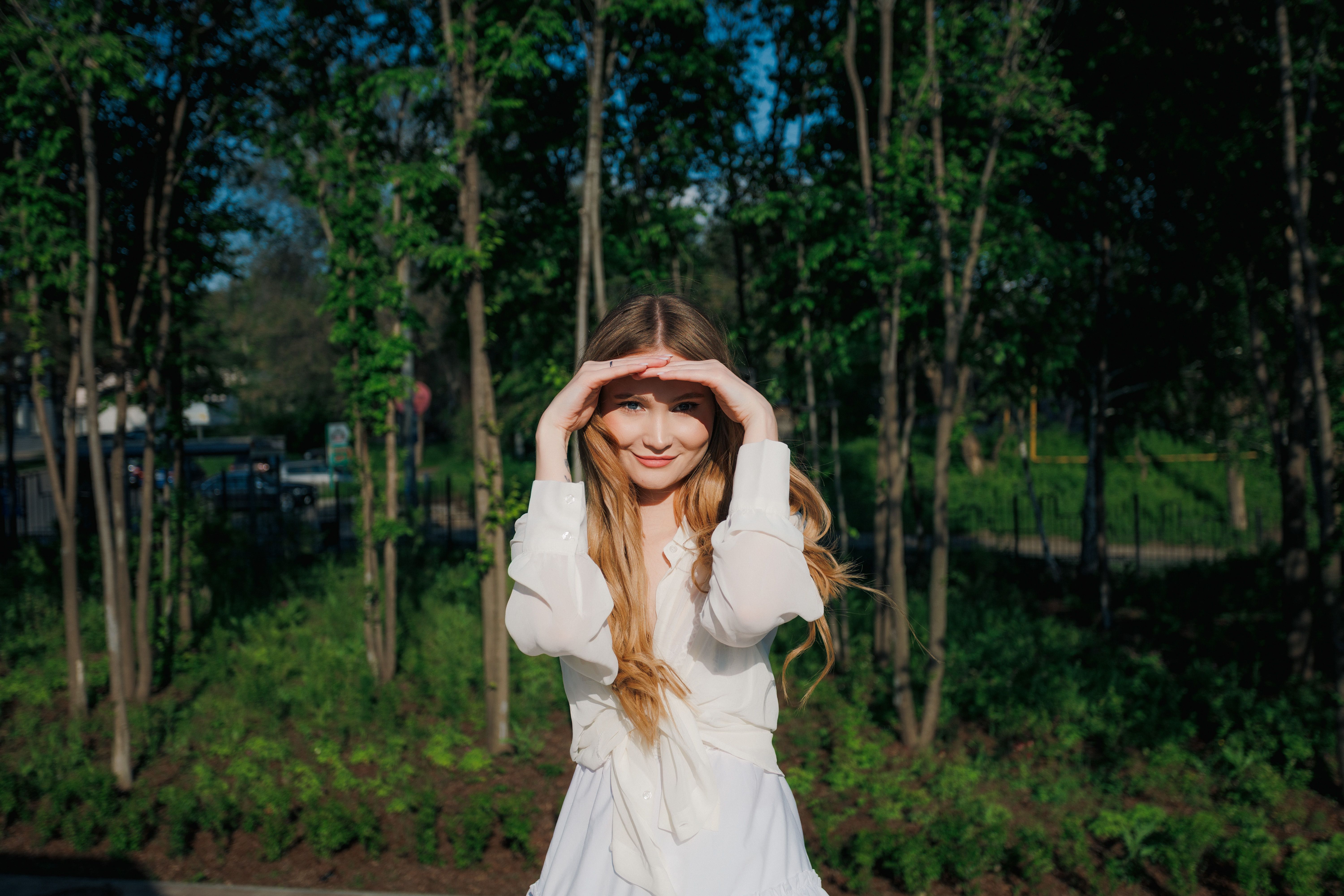 Woman shielding her eyes from bright sun on a sunny summer day outdoors