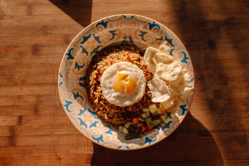 Nasi goreng dengan telur mata sapi dan kerupuk, tampak dari atas