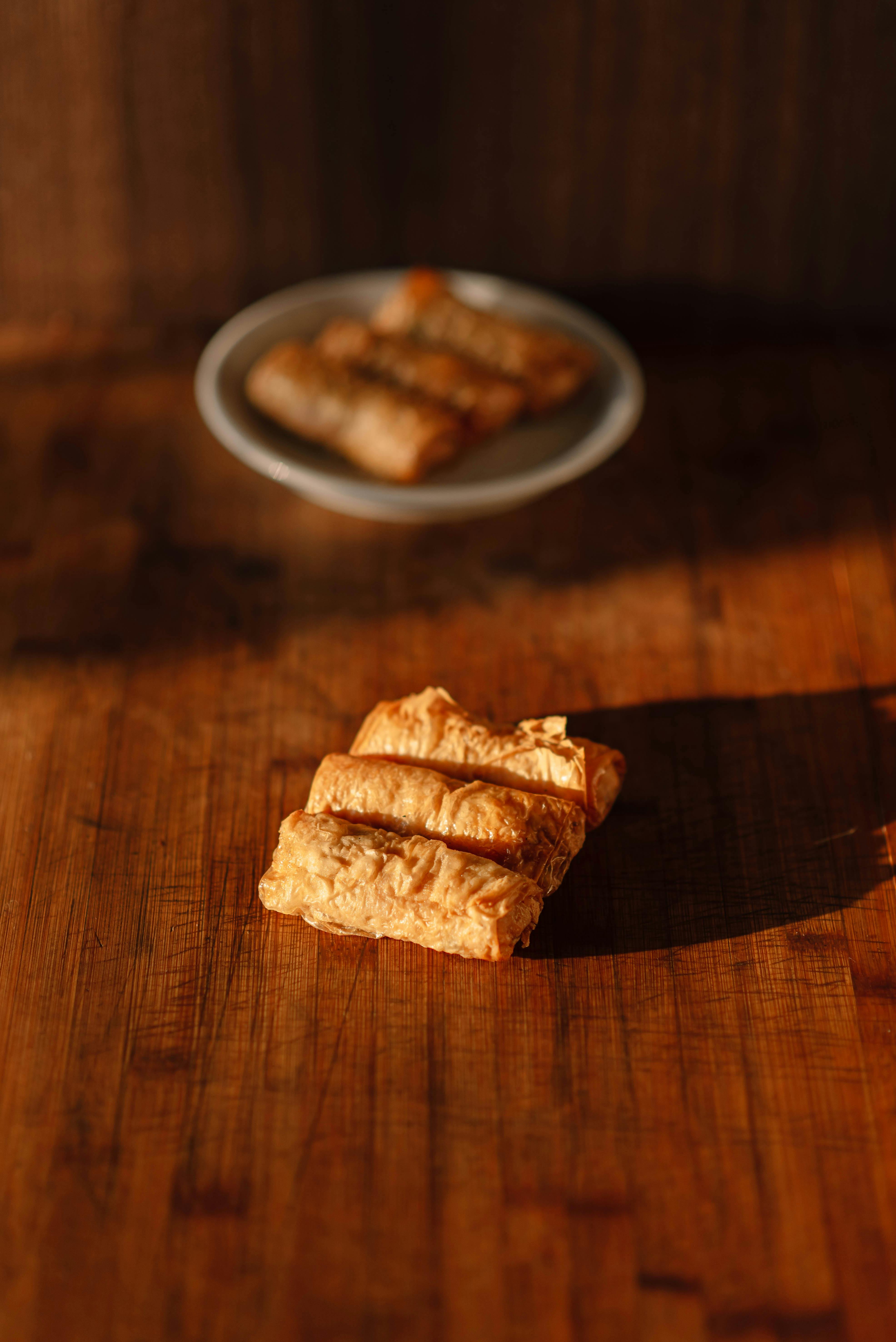 Crispy Spring Rolls on Rustic Wooden Table · Free Stock Photo