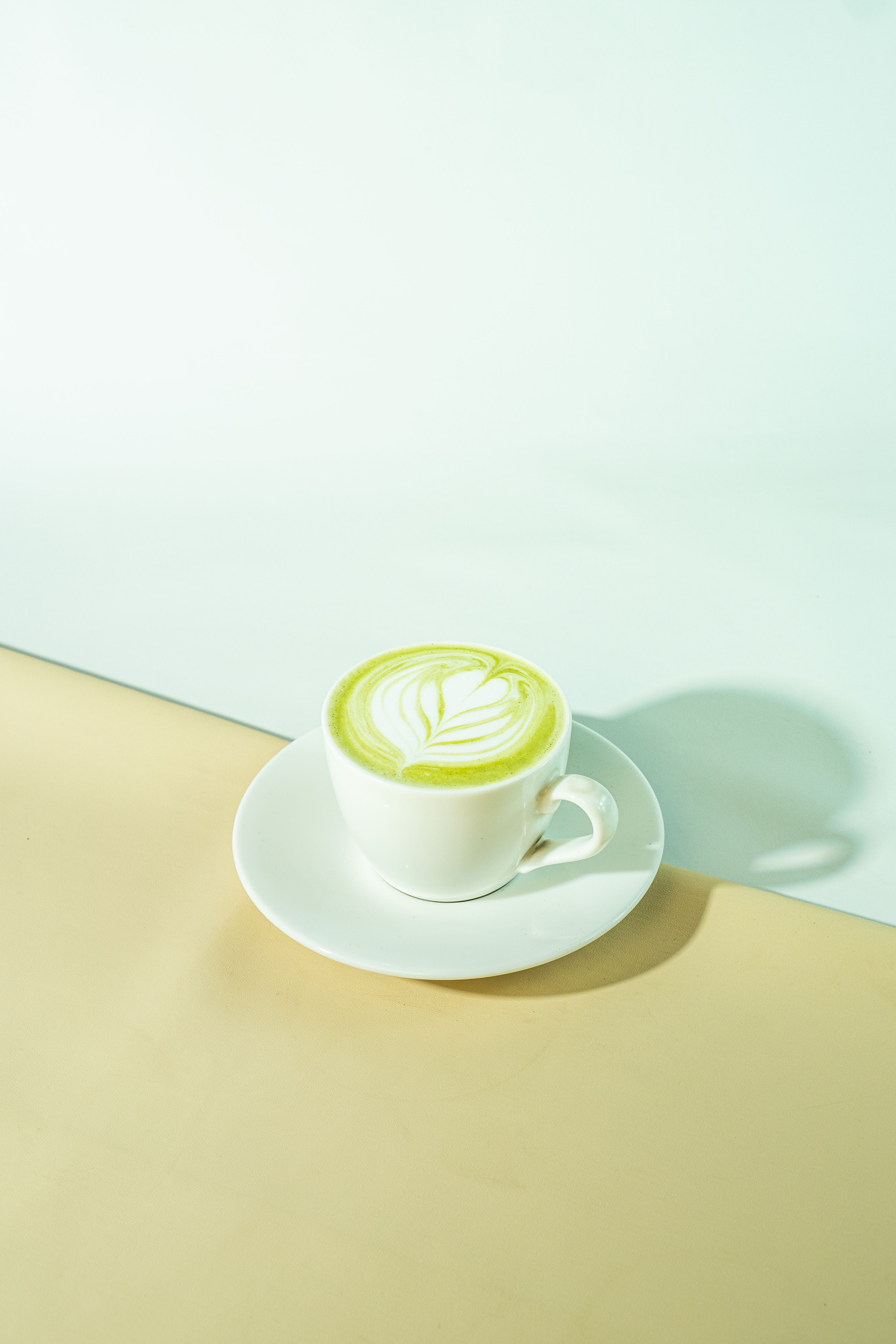Hot matcha latte recipe served in a white cup with leaf-shaped foam art