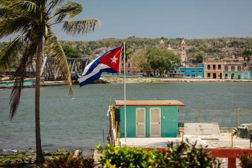 Free Colorful waterfront view with Cuban flag in Matanzas, Cuba under a bright sky. Stock Photo