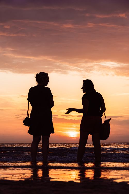 Free Two women silhouette during a vibrant sunset at Middelkerke beach, Belgium. Stock Photo