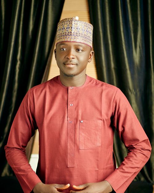 Free Portrait of an adult man wearing traditional attire, smiling indoors. Stock Photo